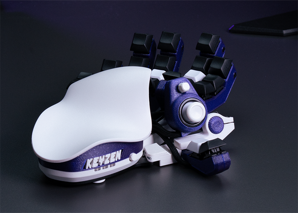 White and blue Azeron device with the name 'Keyzen' on a dark background